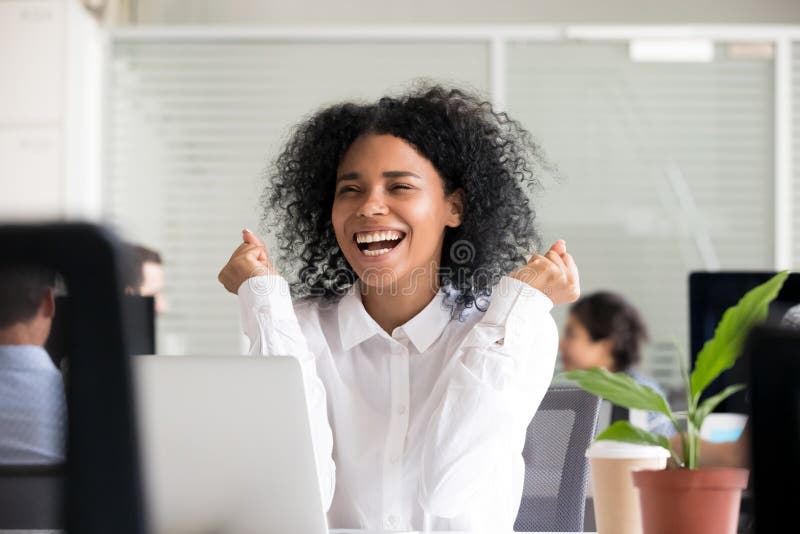 Donna afroamericana emozionante che riceve buone notizie sul computer portatile immagini stock libere da diritti Donna afroamericana emozionante che riceve buone notizie sul computer portatile immagini stock libere da diritti