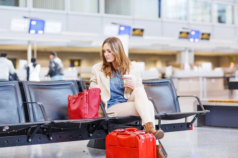 Donna al volo aspettante dell'aeroporto internazionale al terminale fotografia stock Donna al volo aspettante dell'aeroporto internazionale al terminale fotografia stock