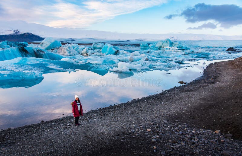 Donna alla laguna del ghiacciaio di Jokulsarlon in Islanda immagini stock libere da diritti Donna alla laguna del ghiacciaio di Jokulsarlon in Islanda immagini stock libere da diritti