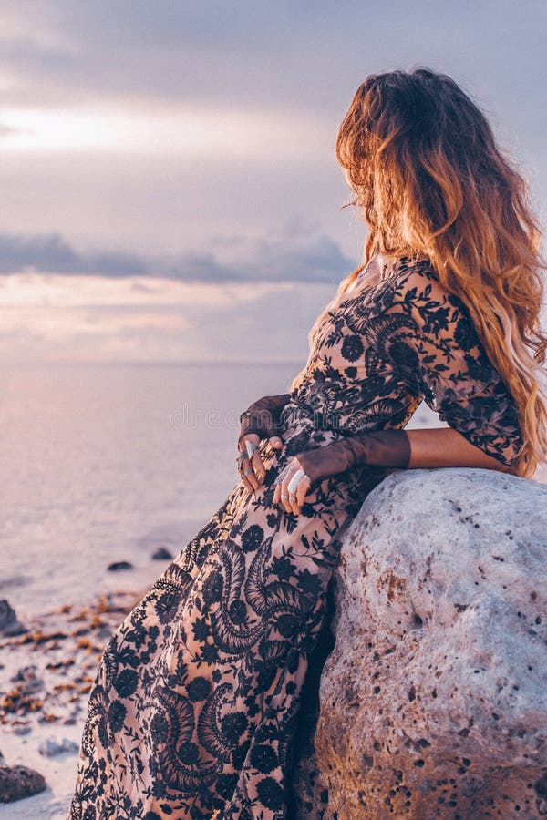 Donna alla moda alla moda con gli accessori di boho sulla spiaggia a fotografie stock