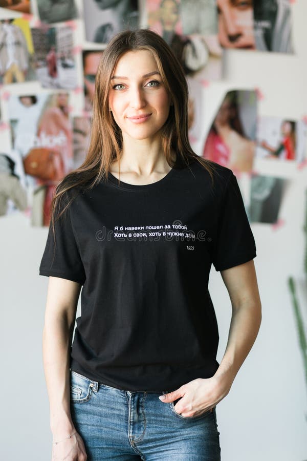 Donna alla moda in una maglietta nera, posante in uno studio fotografia stock Donna alla moda in una maglietta nera, posante in uno studio fotografia stock