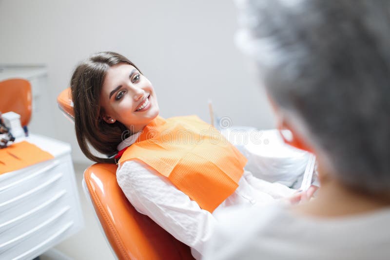 Donna alla ricezione di un dentista in una clinica dentaria fotografia stock Donna alla ricezione di un dentista in una clinica dentaria fotografia stock