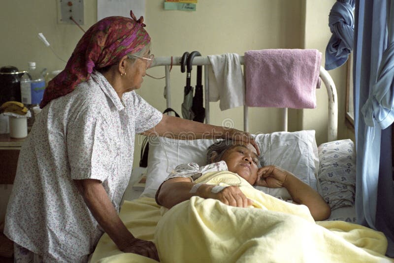 Donna anziana che conforta sorella malata in ospedale