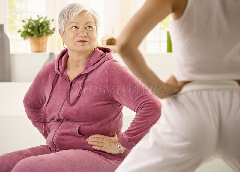 Donna anziana che esamina addestratore personale immagini stock libere da diritti Donna anziana che esamina addestratore personale immagini stock libere da diritti