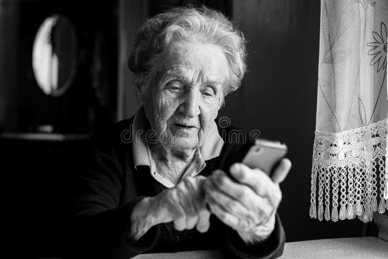 Donna anziana che scrive sullo smartphone Istruzione fotografia stock libera da diritti Donna anziana che scrive sullo smartphone Istruzione fotografia stock libera da diritti