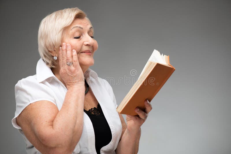 Donna anziana che tiene libro giallo immagine stock libera da diritti Donna anziana che tiene libro giallo immagine stock libera da diritti