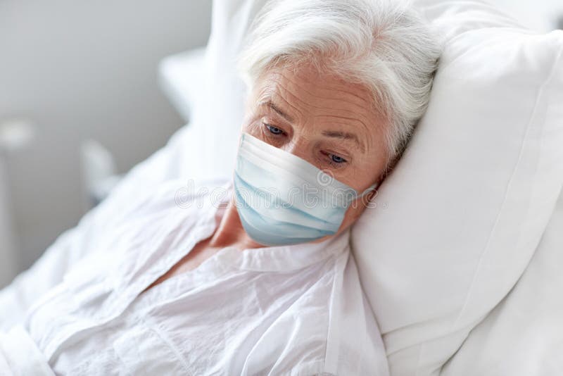 Donna anziana con una maschera nascosta in ospedale a letto