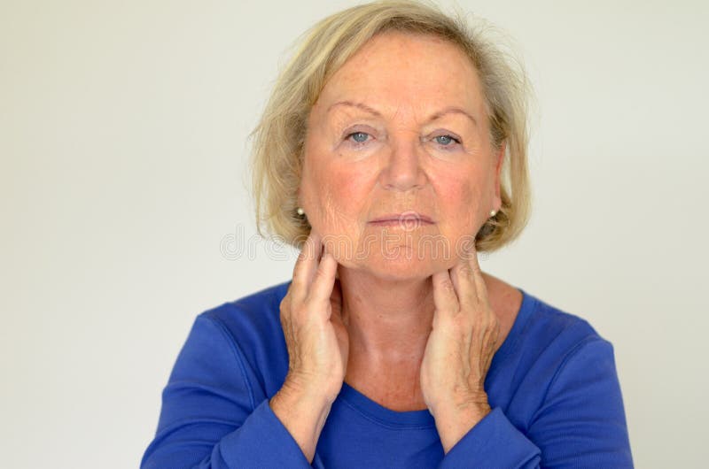 Donna anziana premurosa con le sue mani al suo collo fotografia stock libera da diritti Donna anziana premurosa con le sue mani al suo collo fotografia stock libera da diritti