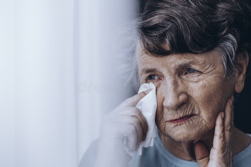 Donna anziana triste che pulisce gli strappi