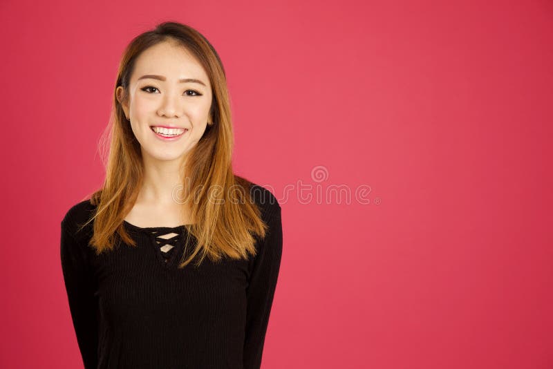 Pretty young asian woman in the studio in pink background. Pretty young asian woman in the studio in pink background