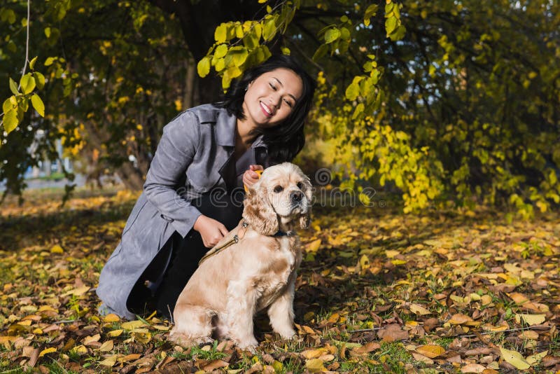 Donna asiatica attraente con il cane nel parco fotografia stock Donna asiatica attraente con il cane nel parco fotografia stock