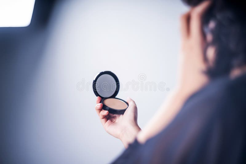 Donna asiatica che compone esaminando il colpo dello studio dello specchio fotografie stock libere da diritti Donna asiatica che compone esaminando il colpo dello studio dello specchio fotografie stock libere da diritti