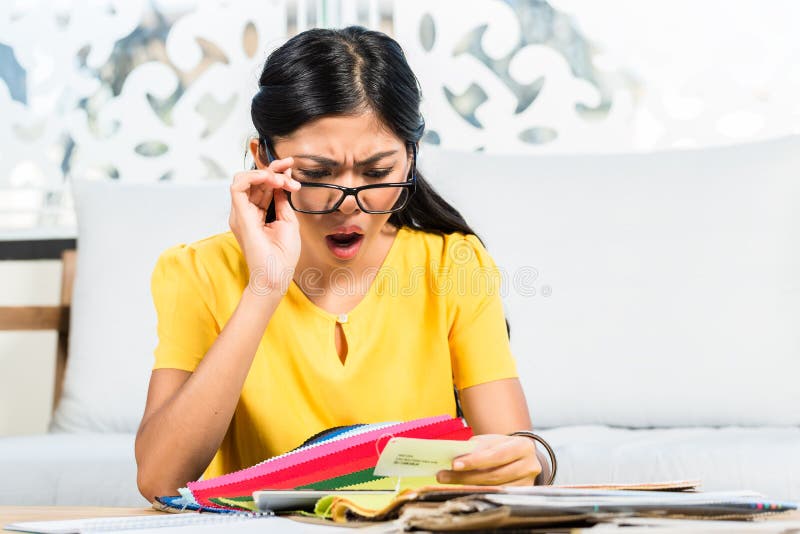 Donna asiatica che controlla prezzo da pagare in negozio di mobili immagine stock Donna asiatica che controlla prezzo da pagare in negozio di mobili immagine stock