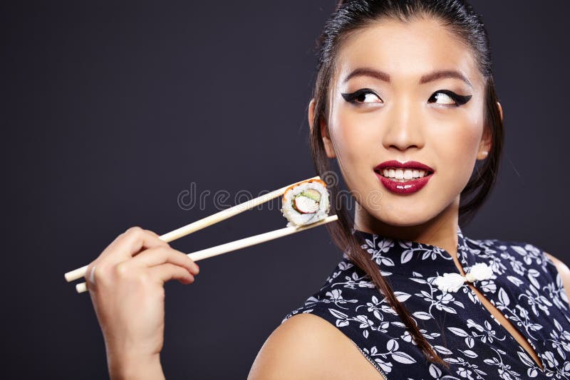 Donna asiatica che mangia i sushi
