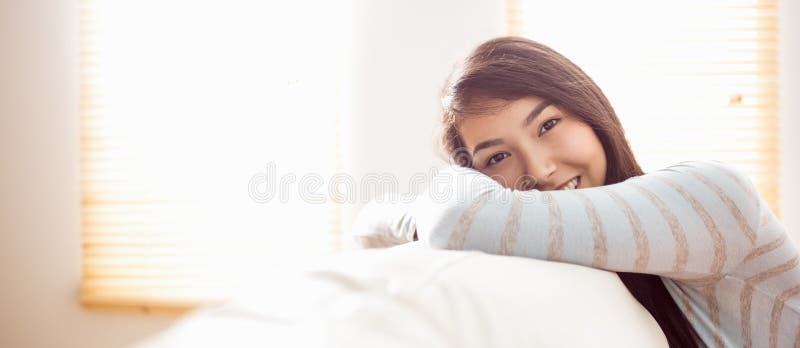 Donna asiatica che si rilassa sullo strato fotografia stock libera da diritti Donna asiatica che si rilassa sullo strato fotografia stock libera da diritti