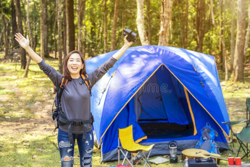 Donna asiatica con binocoli e felice di viaggiare nella foresta donne asiatiche accampate e riposate in foresta felice nel fine s immagini stock Donna asiatica con binocoli e felice di viaggiare nella foresta donne asiatiche accampate e riposate in foresta felice nel fine s immagini stock