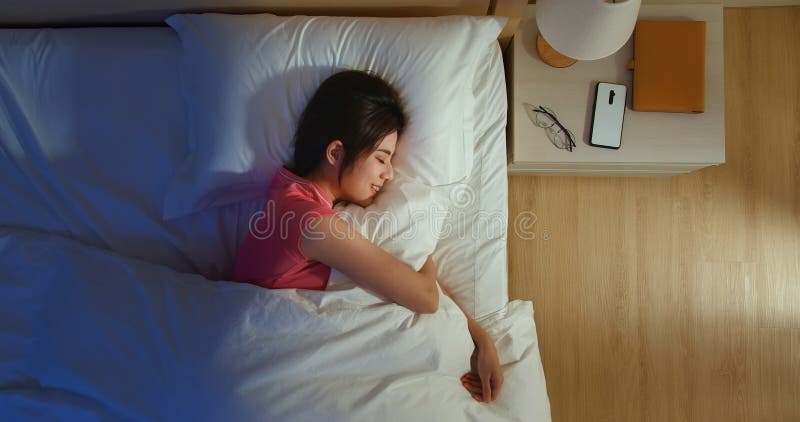 Di notte, la donna asiatica dorme bene con un sorriso