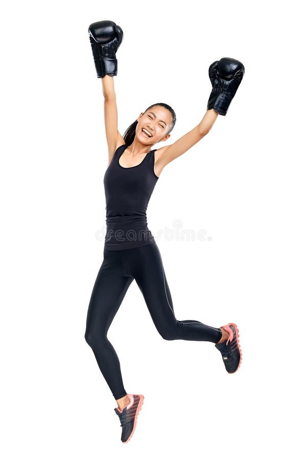 Donna asiatica in guantoni da pugile che saltano nel trionfo della vittoria fotografia stock libera da diritti Donna asiatica in guantoni da pugile che saltano nel trionfo della vittoria fotografia stock libera da diritti