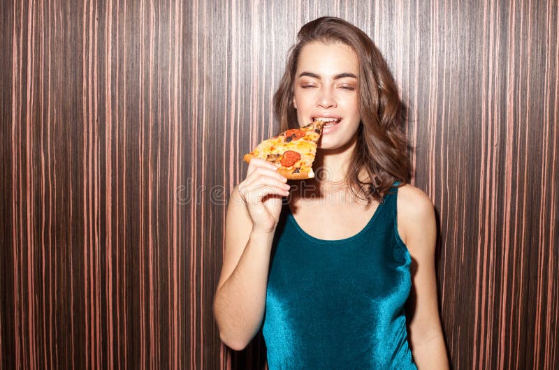 Donna attraente con il pezzo della pizza fotografie stock Donna attraente con il pezzo della pizza fotografie stock