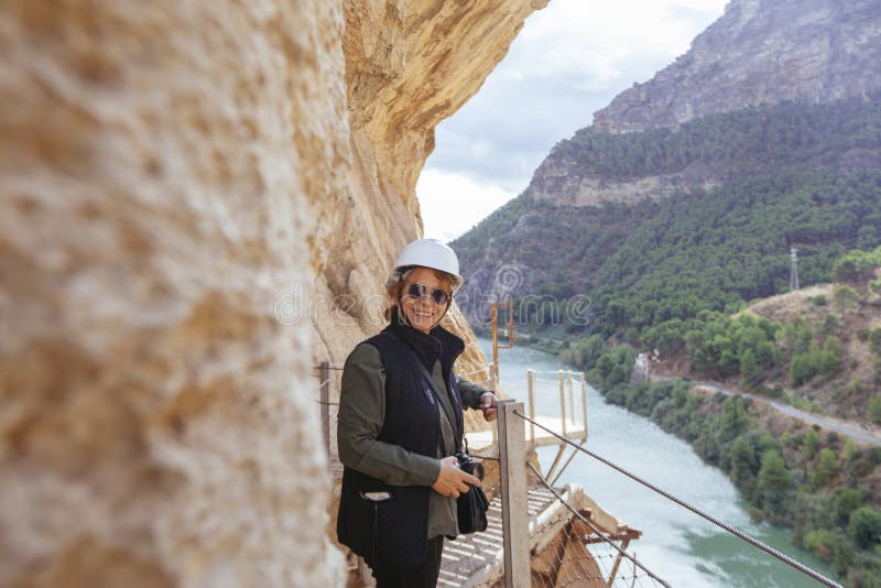 Donna avventurosa con il casco che prende le immagini sulle sue feste immagine stock libera da diritti Donna avventurosa con il casco che prende le immagini sulle sue feste immagine stock libera da diritti