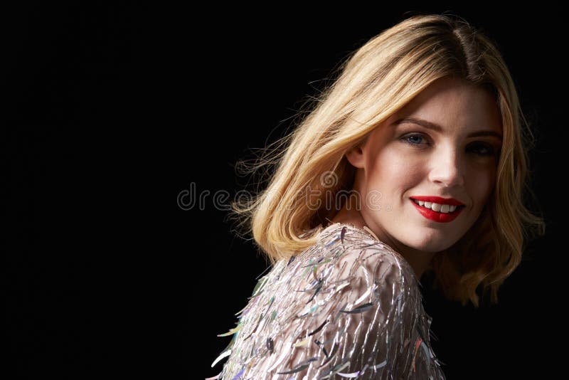 Donna bionda affascinante che si gira verso la macchina fotografica, spalle cape fotografia stock Donna bionda affascinante che si gira verso la macchina fotografica, spalle cape fotografia stock