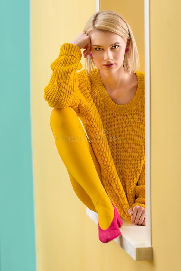donna bionda alla moda nella seduta gialla del maglione fotografia stock libera da diritti donna bionda alla moda nella seduta gialla del maglione fotografia stock libera da diritti