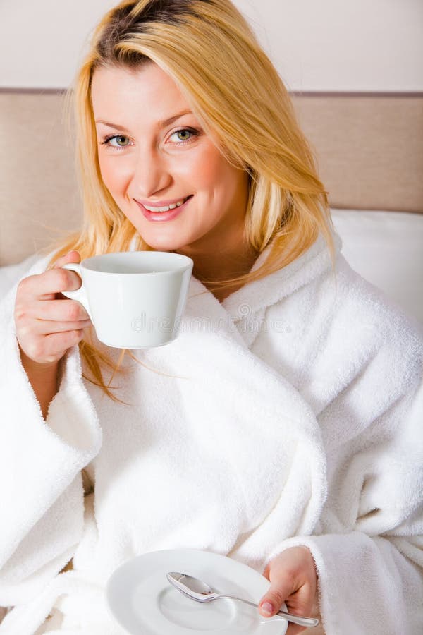 Donna bionda che mangia il caffè di mattina fotografie stock libere da diritti Donna bionda che mangia il caffè di mattina fotografie stock libere da diritti