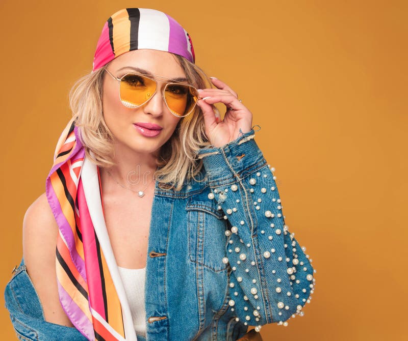 Donna bionda sensuale con il foulard colorato che ripara la sua Unione Sovietica gialla fotografia stock libera da diritti Donna bionda sensuale con il foulard colorato che ripara la sua Unione Sovietica gialla fotografia stock libera da diritti
