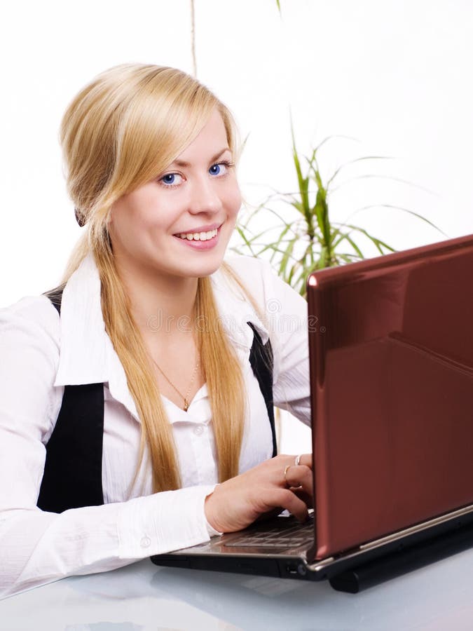 Donna bionda sorridente che lavora con il calcolatore immagini stock