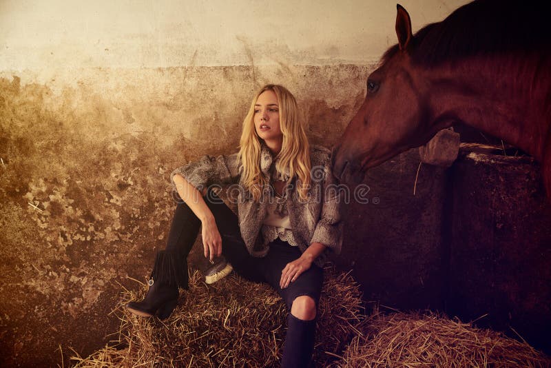 Donna bionda su una stalla dell'interno con il cavallo immagini stock libere da diritti Donna bionda su una stalla dell'interno con il cavallo immagini stock libere da diritti