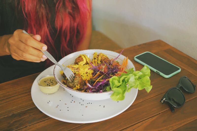 Donna in buona salute di stile di vita che mangia le palle del Falafel del vegano con insalata verde fresca in ristorante vegetar immagini stock Donna in buona salute di stile di vita che mangia le palle del Falafel del vegano con insalata verde fresca in ristorante vegetar immagini stock
