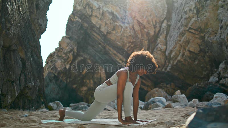 Donna calma che esegue yoga asana durante la giornata estiva di sabbia sulla spiaggia di ursa. ragazza che esercita. stock footage