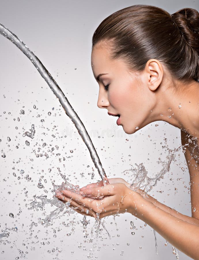 Closeup portrait of a caucasian woman washing her clean face with water. Closeup portrait of a caucasian woman washing her clean face with water