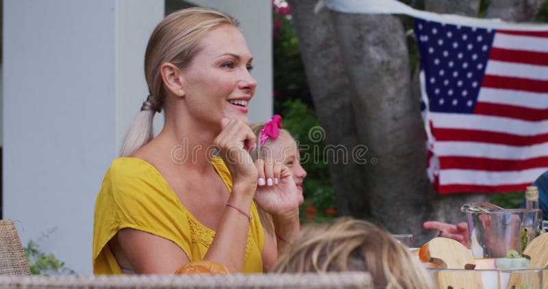 Donna caucasica che parla in giardino a cena per le celebrazioni della famiglia