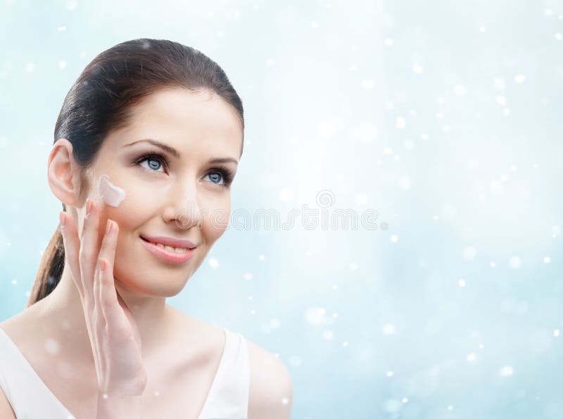 Donna che applica crema sul suo fronte - facial di inverno fotografia stock libera da diritti Donna che applica crema sul suo fronte - facial di inverno fotografia stock libera da diritti