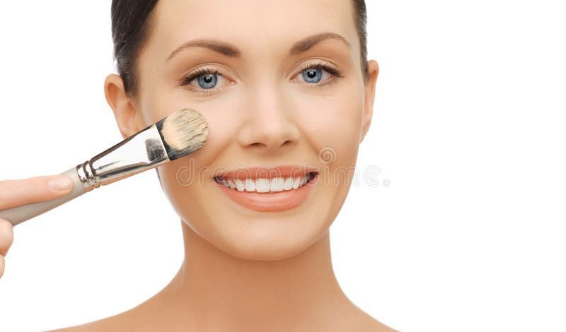 Donna che applica fondamento liquido con la spazzola fotografia stock libera da diritti Donna che applica fondamento liquido con la spazzola fotografia stock libera da diritti