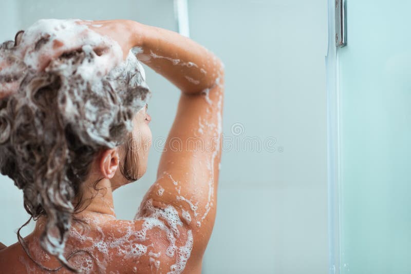 Donna che applica sciampo in acquazzone
