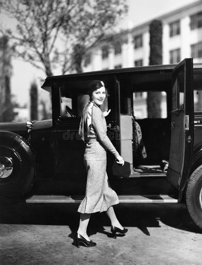 Donna che cammina all'automobile (tutte le persone rappresentate non sono vivente più lungo e nessuna proprietà esiste Garanzie d immagine stock libera da diritti Donna che cammina all'automobile (tutte le persone rappresentate non sono vivente più lungo e nessuna proprietà esiste Garanzie d immagine stock libera da diritti