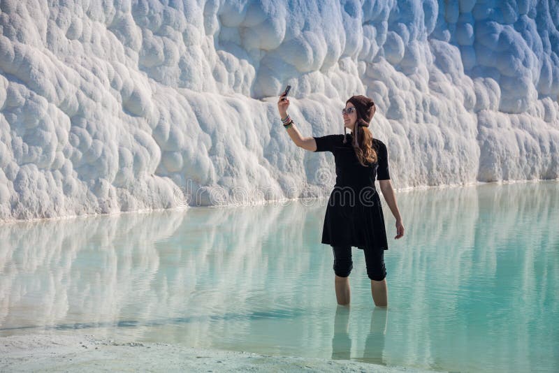 Donna che cammina sui terrazzi a Pamukkale Castello del cotone nel turco ed è sito naturale fotografia stock Donna che cammina sui terrazzi a Pamukkale Castello del cotone nel turco ed è sito naturale fotografia stock