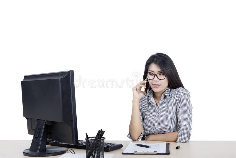 Donna che chiama qualcuno mentre lavora sul suo desktop