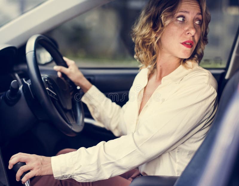 Donna che conduce un'automobile al contrario fotografia stock libera da diritti Donna che conduce un'automobile al contrario fotografia stock libera da diritti
