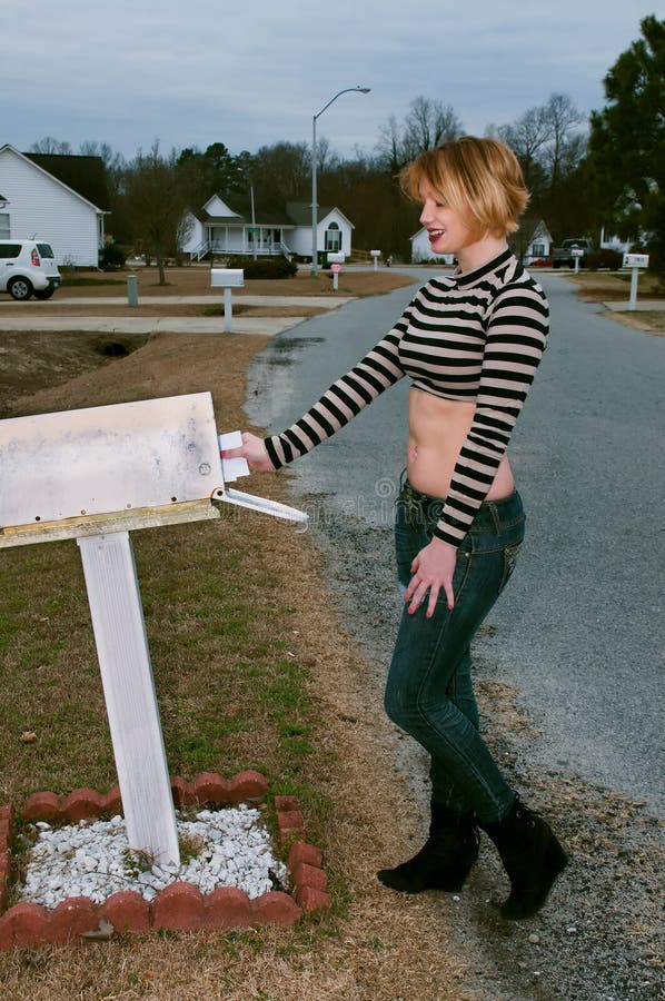Beautiful young woman checking a mailbox for mail. Beautiful young woman checking a mailbox for mail
