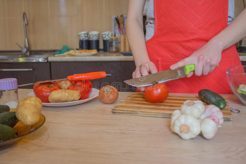 Donna che cucina pasto sano nella cucina Cucinando alimento sano a casa Donna in cucina che prepara le verdure Tagli del cuoco un fotografia stock libera da diritti Donna che cucina pasto sano nella cucina Cucinando alimento sano a casa Donna in cucina che prepara le verdure Tagli del cuoco un fotografia stock libera da diritti