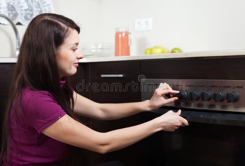 Donna che cucina qualcosa nel forno fotografie stock Donna che cucina qualcosa nel forno fotografie stock