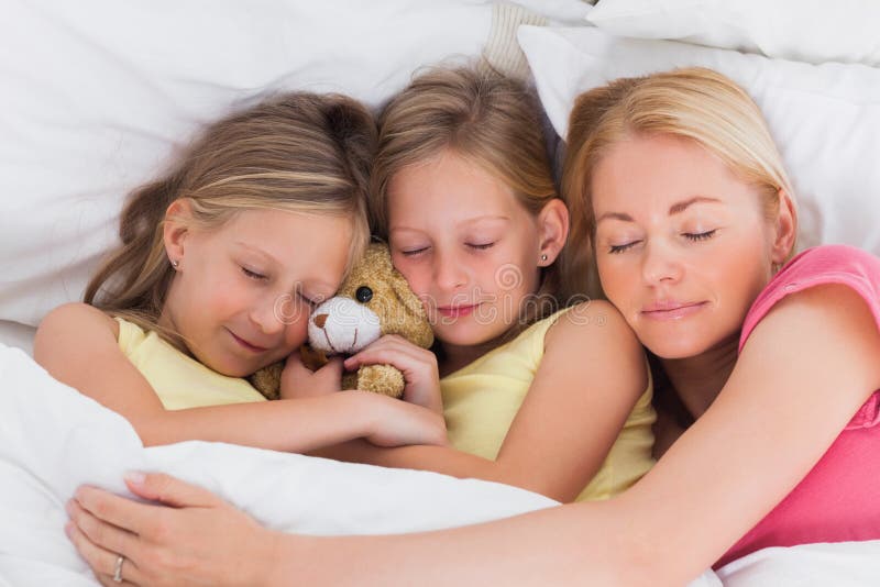 Donna che dorme a letto con i suoi bambini svegli fotografie stock libere da diritti Donna che dorme a letto con i suoi bambini svegli fotografie stock libere da diritti