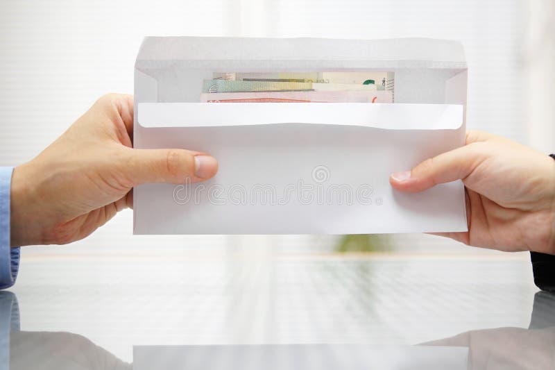 Donna che consegna una busta con denaro a un uomo fotografia stock libera da diritti