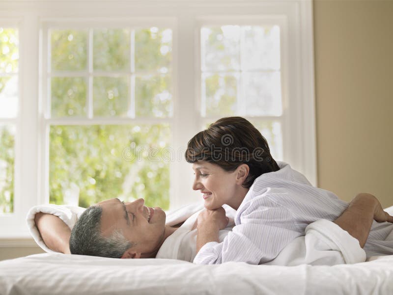 Donna che esamina marito mentre trovandosi a letto