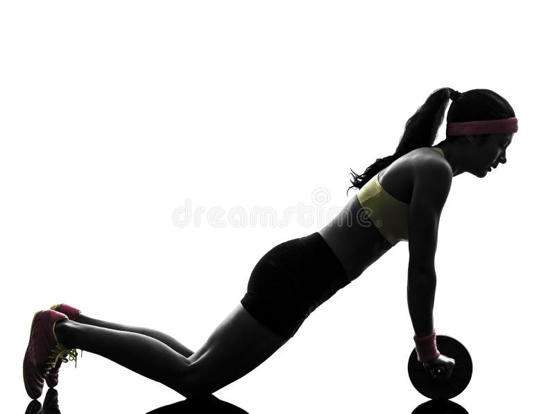 Donna che esercita il silhouet di tonalità addominale della ruota di allenamento di forma fisica fotografia stock Donna che esercita il silhouet di tonalità addominale della ruota di allenamento di forma fisica fotografia stock