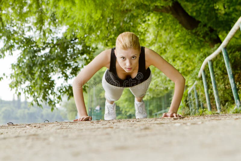 Donna che fa i push-ups all'aperto fotografie stock libere da diritti Donna che fa i push-ups all'aperto fotografie stock libere da diritti