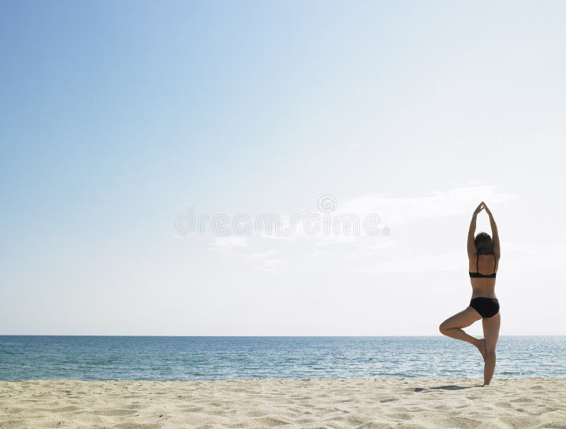 Donna che fa yoga alla spiaggia fotografia stock libera da diritti Donna che fa yoga alla spiaggia fotografia stock libera da diritti
